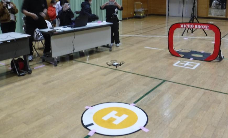ドローンが丸いHの場所の上を飛んでいる様子の写真