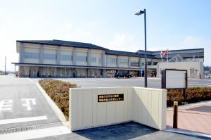 手前の広い駐車場の奥に建つ松川学習センターの外観全体を写した写真
