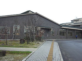 通路奥に建つ黒い外壁の吾妻学習センターの写真