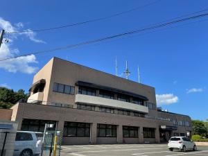 ベージュの外観をした3階建ての四角の形をした飯野学習センター本館の外観全体を写した写真