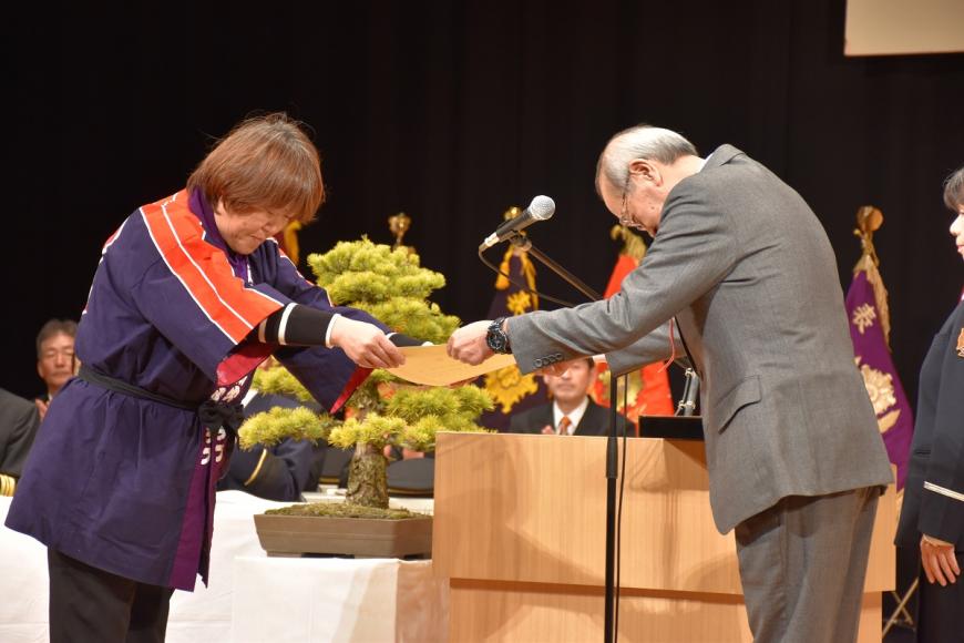 紫色の法被を着た男性が福島東ロータリークラブ会長表彰を受け取っている写真