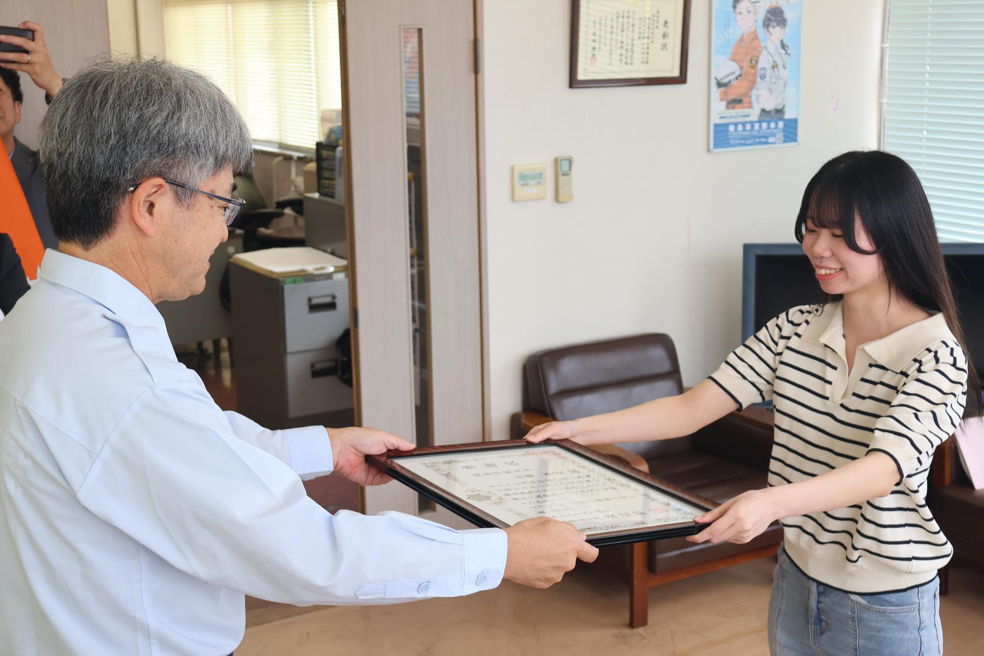 福島市消防長から福島学院大学の学生へ感謝状を手交している写真