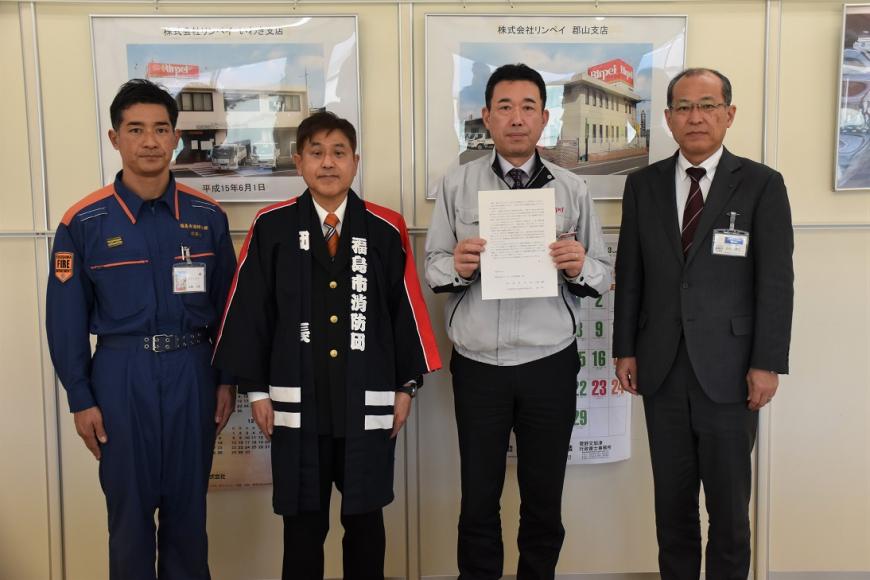 1人の男性が協力要請書を持って男性4名で撮影している写真