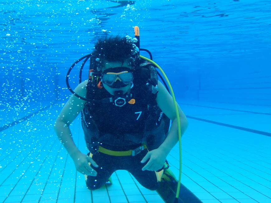 水中でウェットスーツを着用、ボンベをつけた隊員を正面から撮影した水難救助隊訓練の様子の写真
